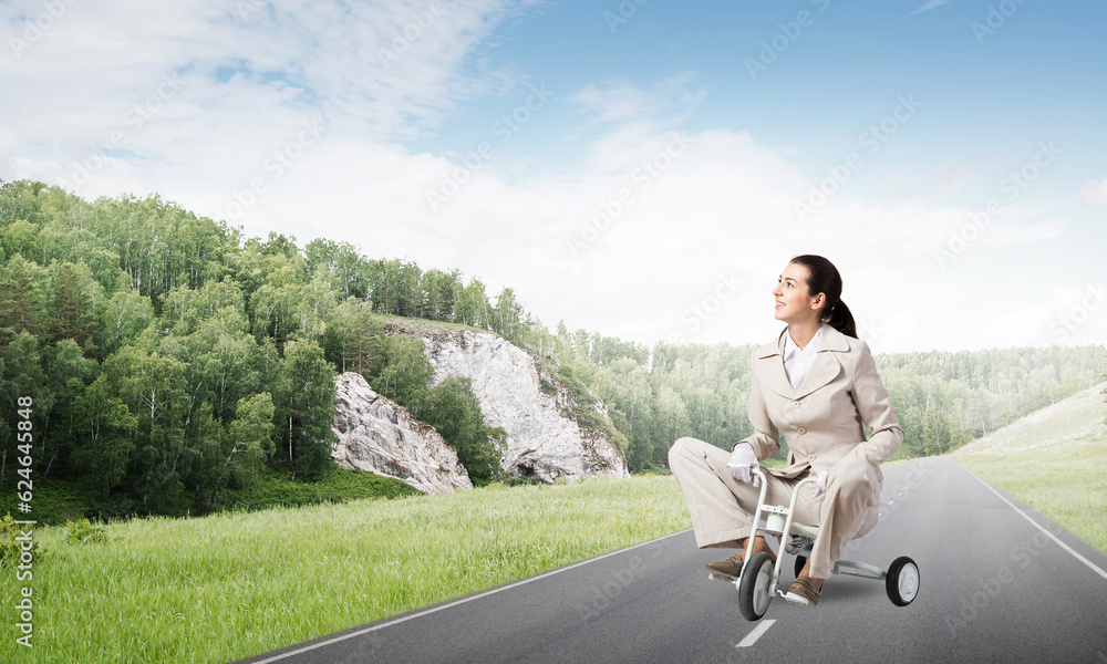 Beautiful caucasian woman riding kids bicycle