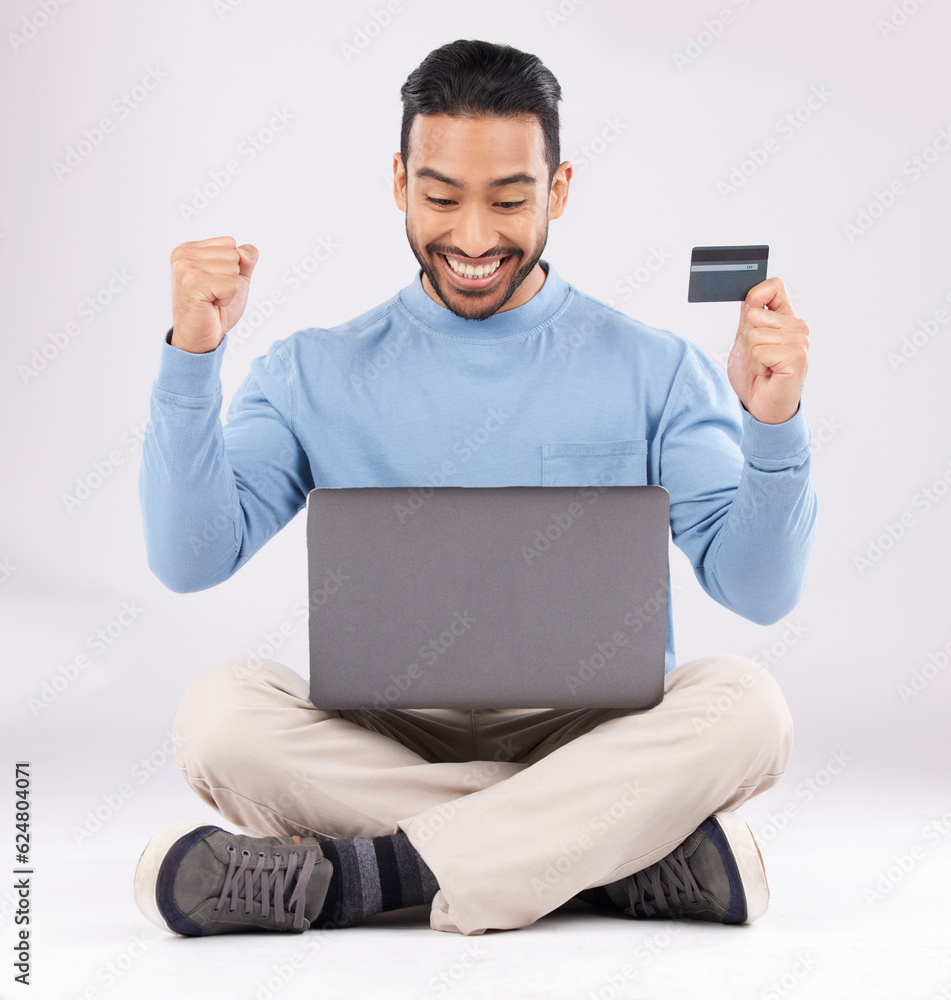 Celebration, laptop and asian man with credit card in studio excited for cashback bonus on grey back