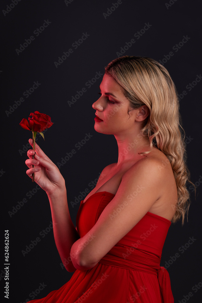 Beauty, fashion and woman with a rose on a dark, black background in a studio thinking of love, roma