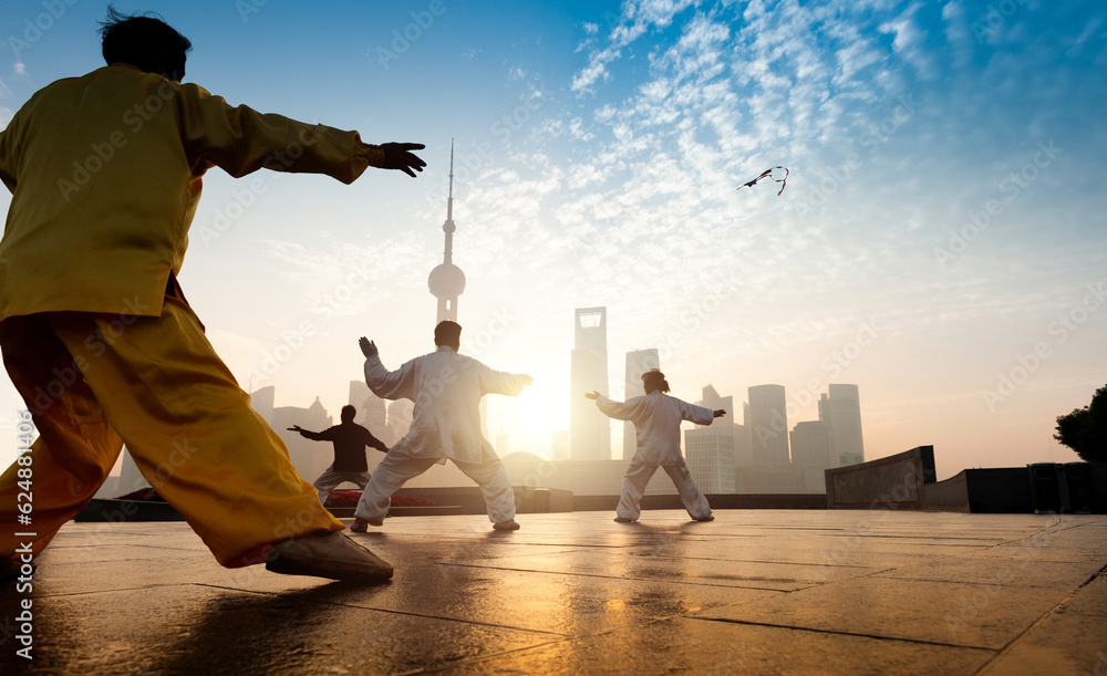 People practice taiji on the bund, oriental pearl tower in the distance,  in Shanghai, China