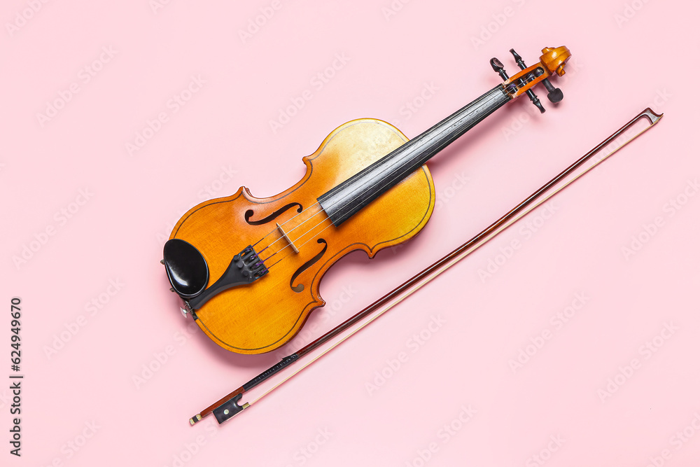 Beautiful violin with bow on color background