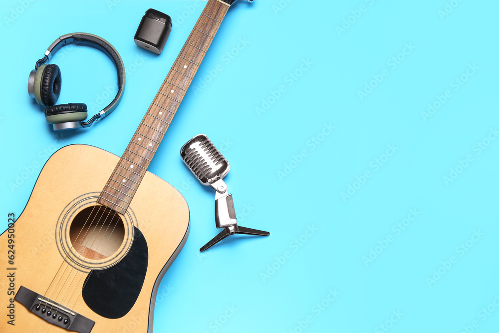 Guitar, headphones and microphone on color background