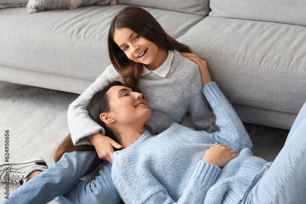 Little girl and her mother in knitted sweaters resting at home