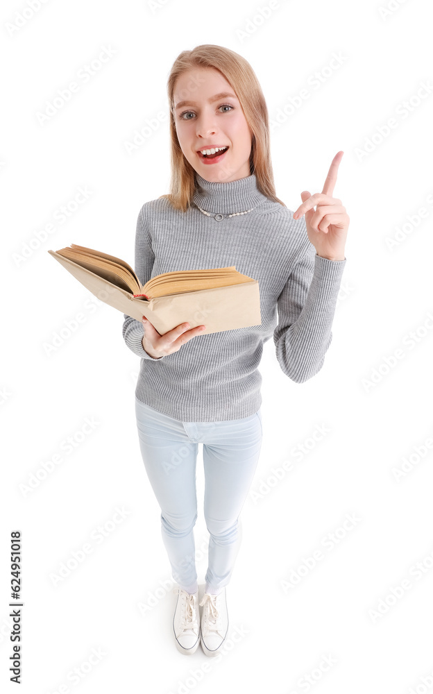 Young woman with open book pointing at something on white background