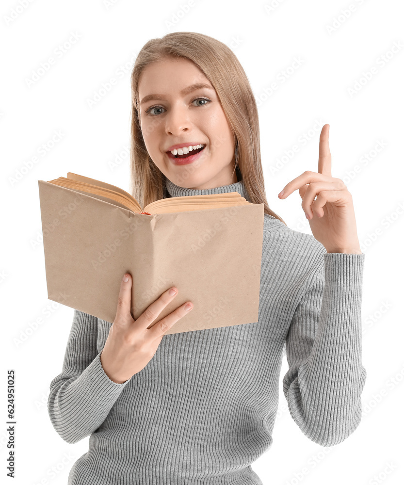 Young woman with open book pointing at something on white background