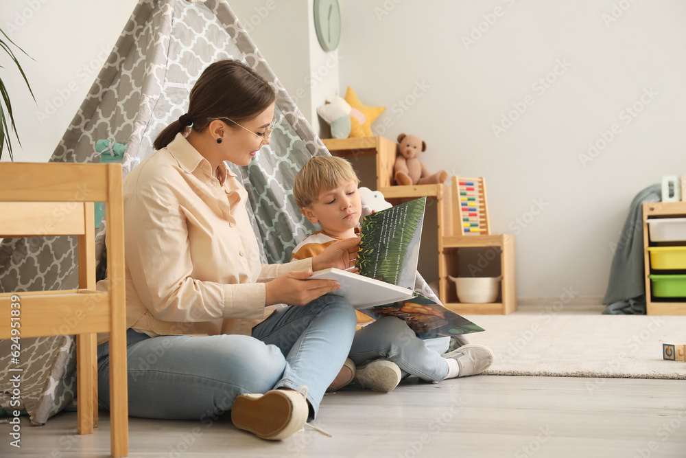 Nanny reading fairy-tale to little boy at home