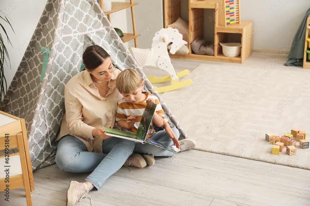 Nanny reading fairy-tale to little boy at home