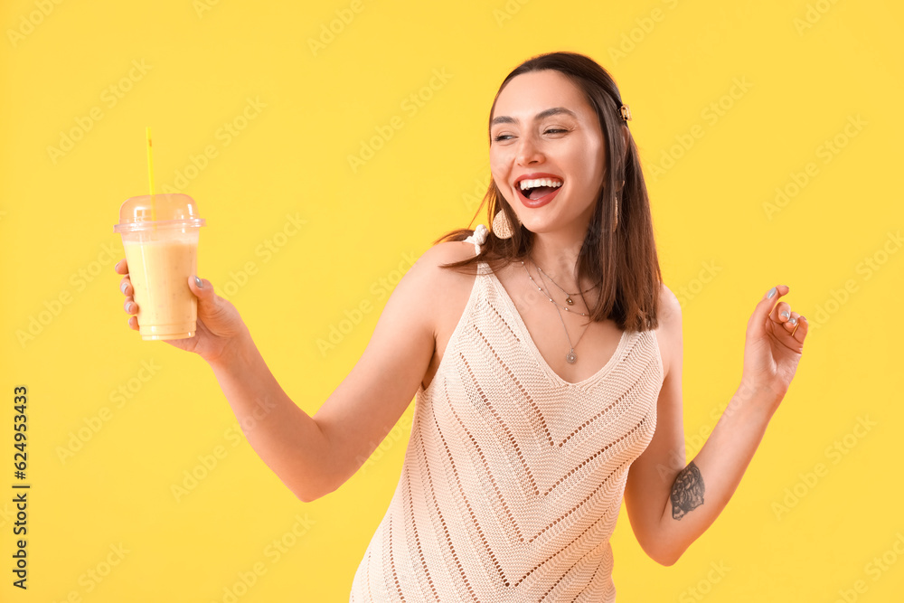 Young woman with glass of smoothie on yellow background