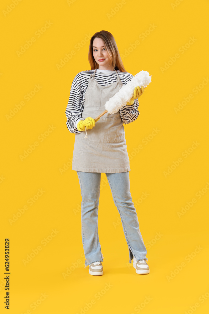 Young woman with pp-duster on yellow background