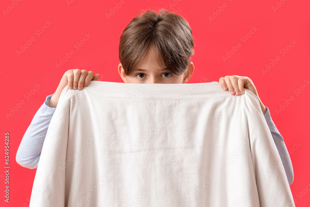 Little boy with blanket on red background