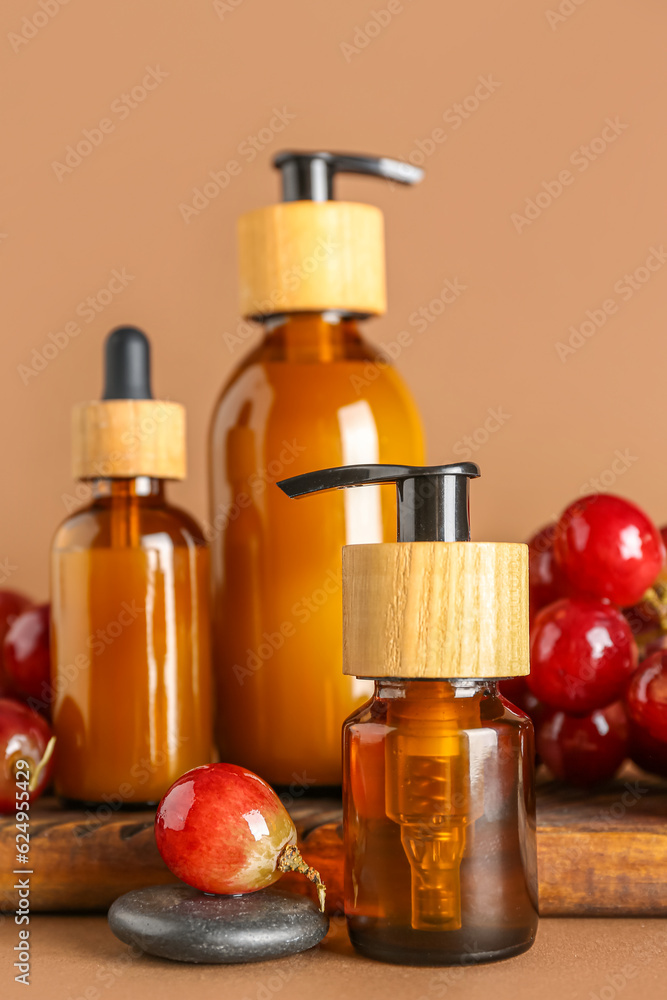 Set of cosmetic products and ripe grapes on color background, closeup