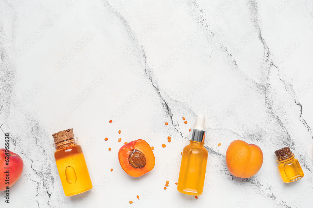 Composition with bottles of essential oil and apricots on light background