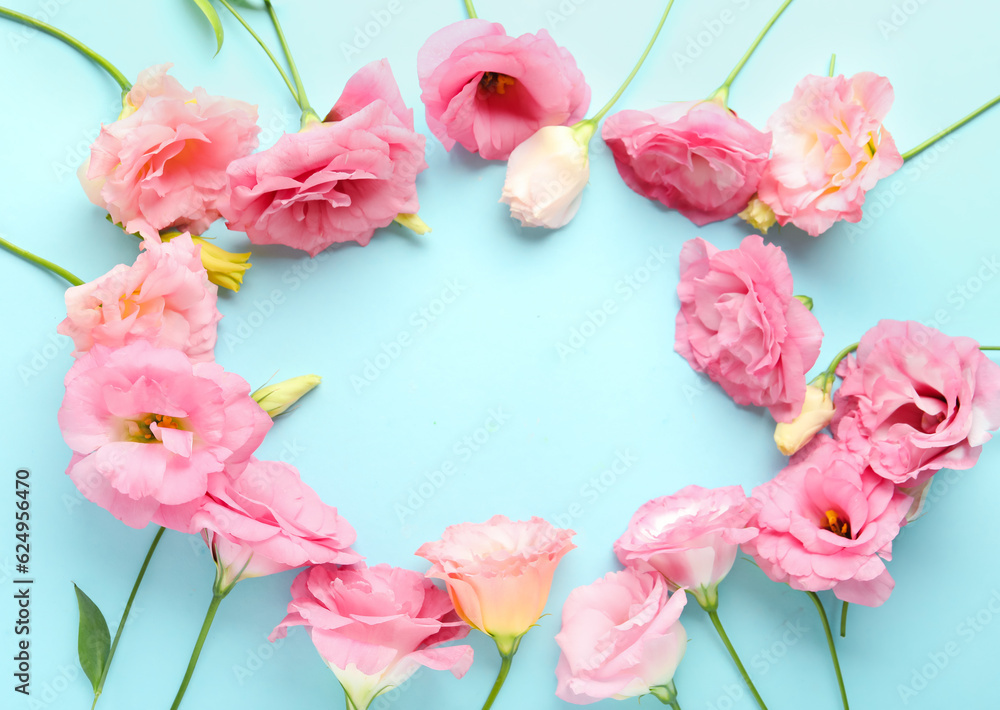 Frame made of beautiful pink eustoma flowers on blue background