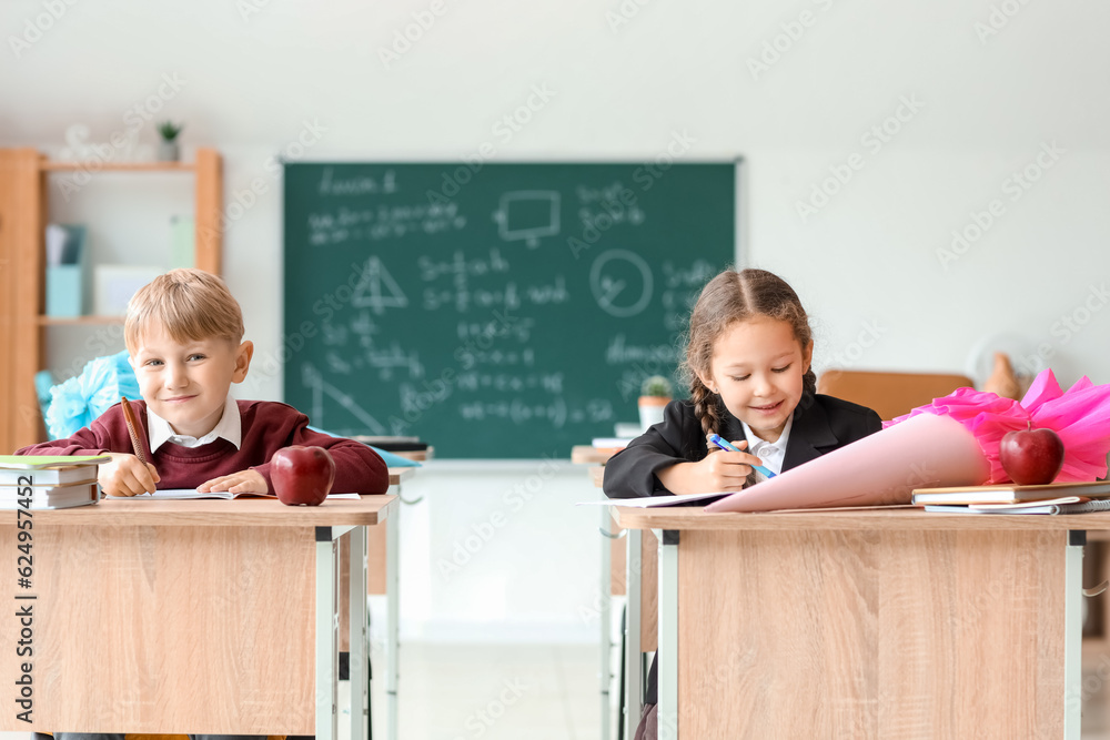 Classmates with school cones sitting at desks in classroom