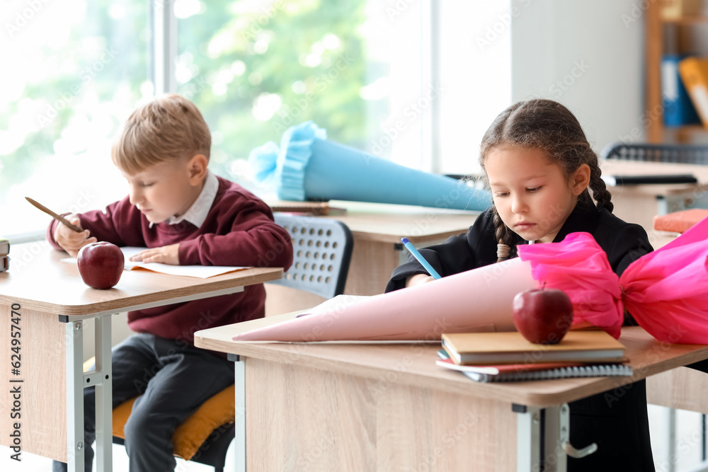 Classmates with school cones sitting at desks in classroom