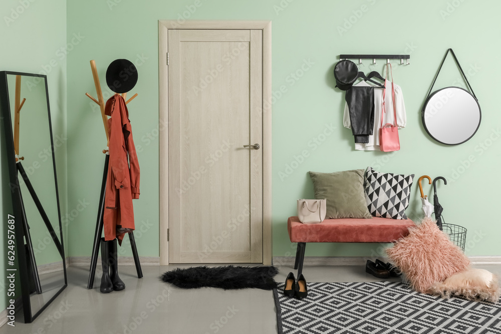 Interior of hallway with mirrors, door, bench and racks