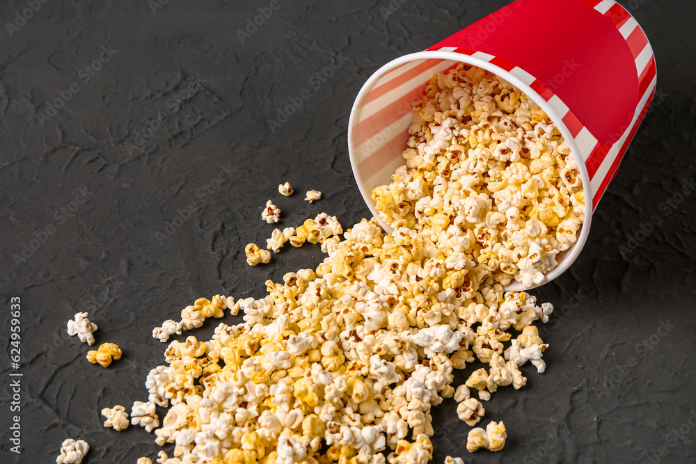 Bucket with tasty popcorn on black background