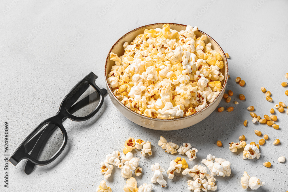 Bowl with tasty popcorn and 3D glasses on grey background