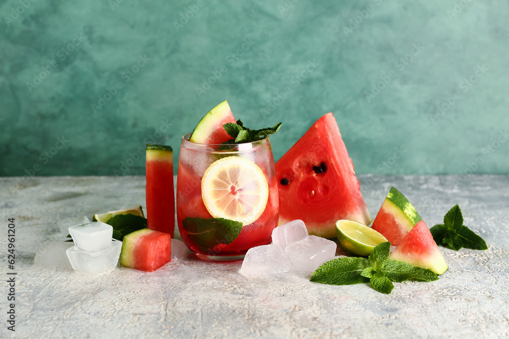 Glass of fresh watermelon lemonade with mint on grey table