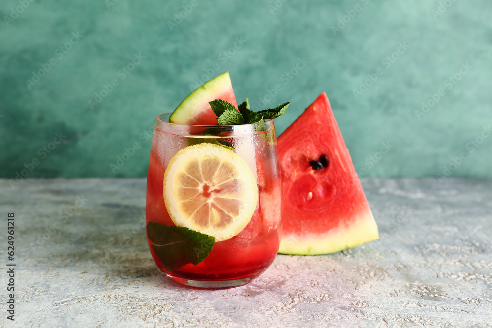 Glass of fresh watermelon lemonade with mint on grey table