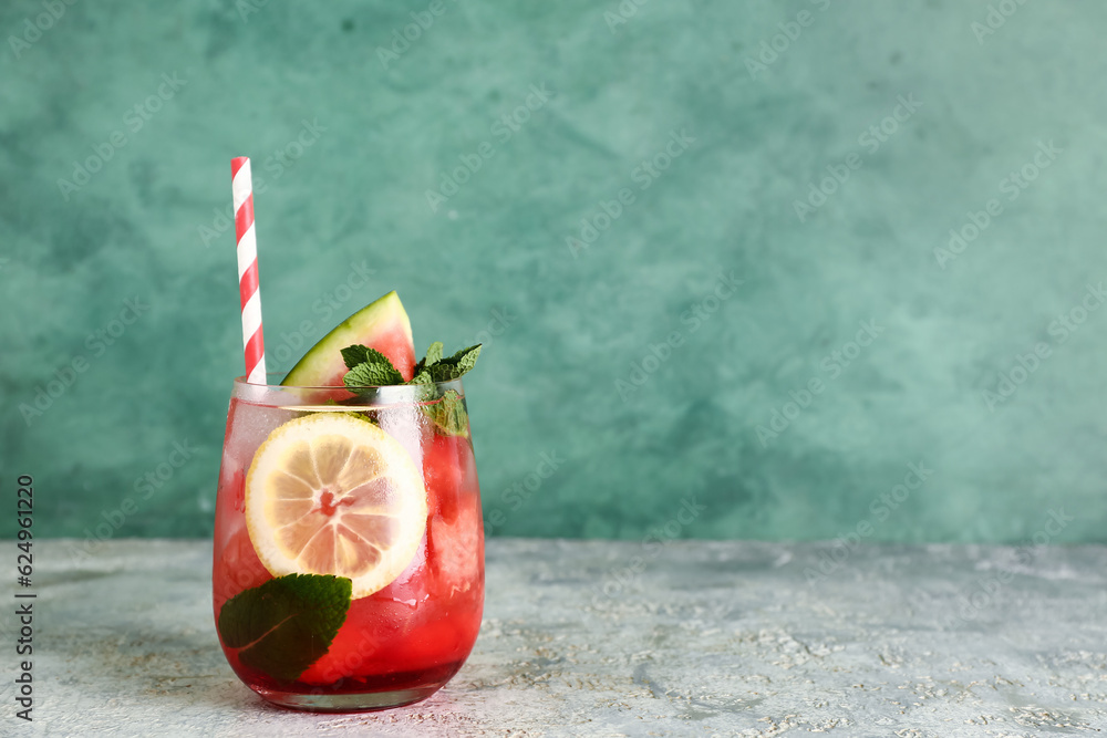 Glass of fresh watermelon lemonade with mint on grey table