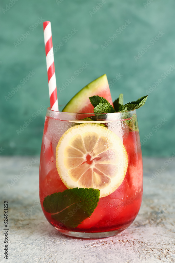 Glass of fresh watermelon lemonade with mint on grey table