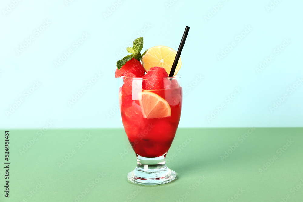 Glass of fresh watermelon lemonade with mint on green table