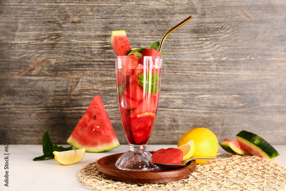 Glass of fresh watermelon lemonade with mint on white table