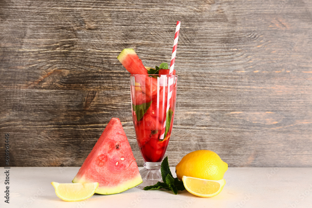 Glass of fresh watermelon lemonade with mint on white table