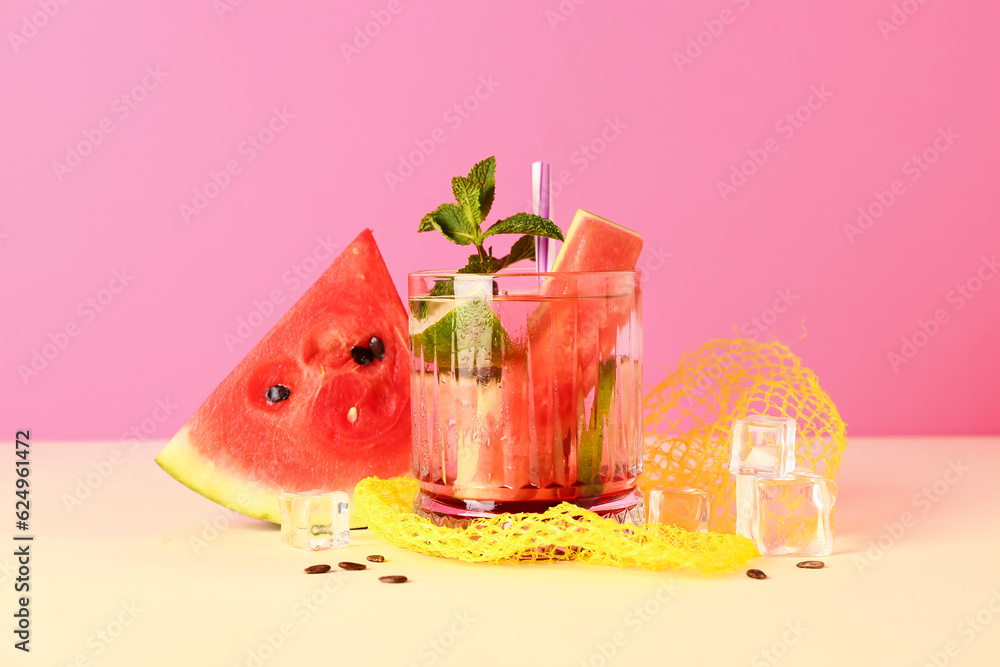 Glass of fresh watermelon lemonade with lime and mint on yellow table