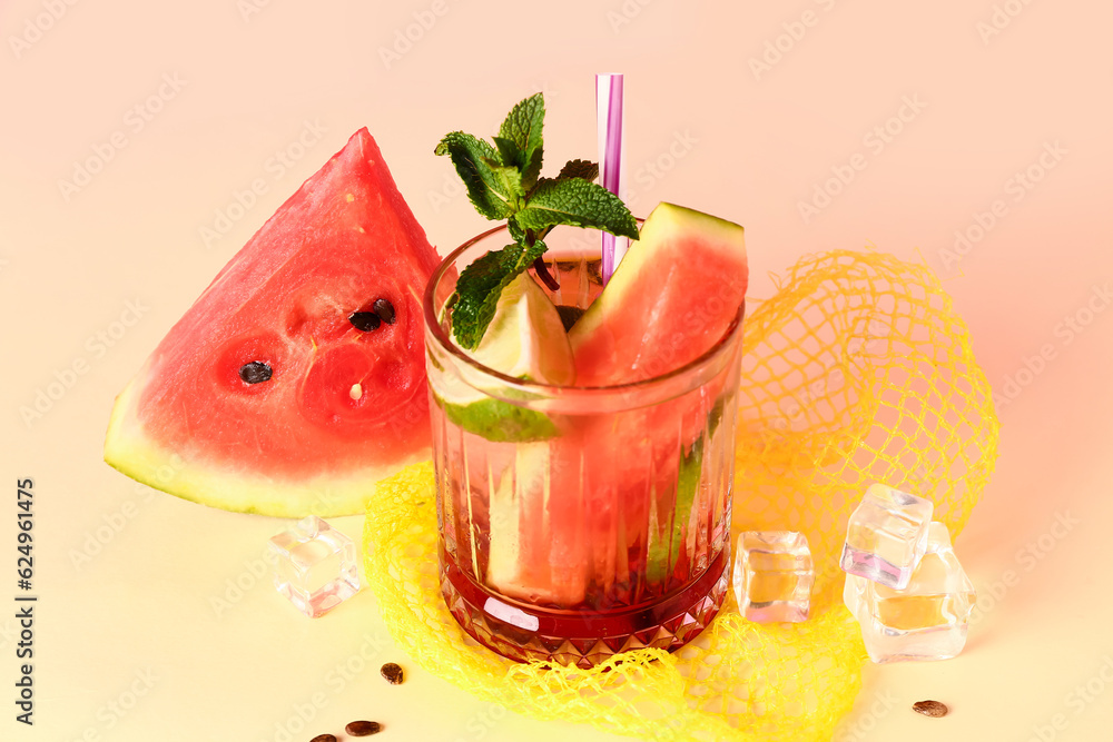 Glass of fresh watermelon lemonade with lime and mint on yellow table