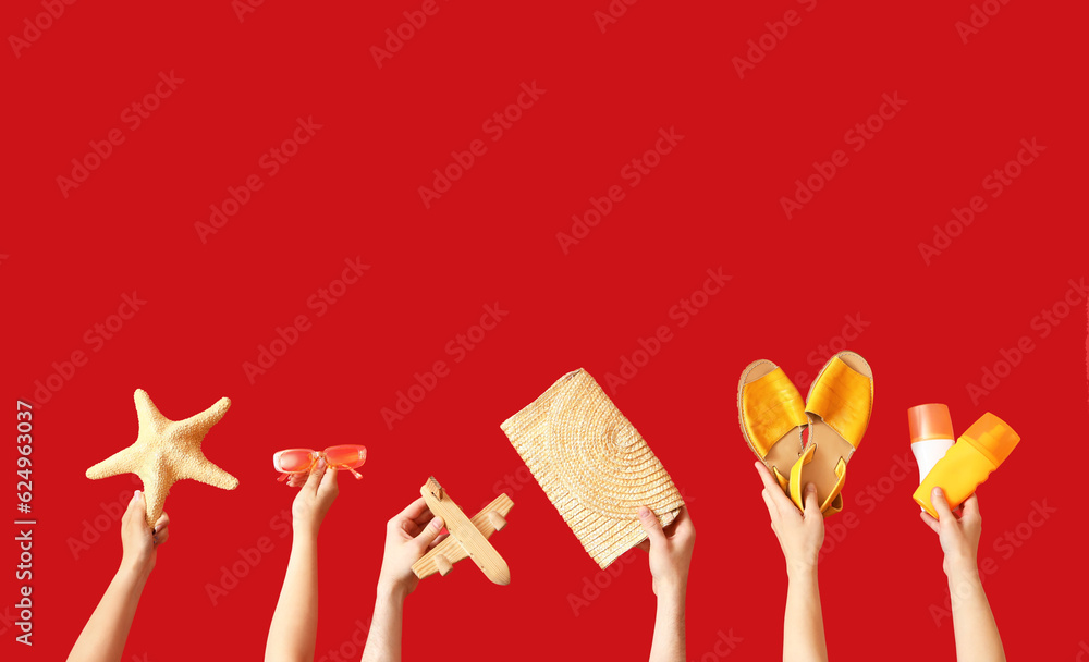 Many hands with beach accessories on red background