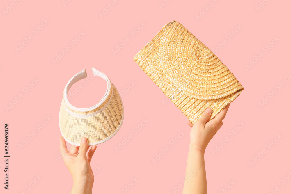 Female hands with wicker bag and tennis cap on pink background