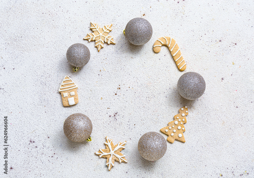 Frame made of Christmas balls and gingerbread cookies on white background