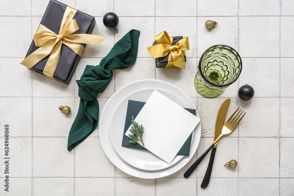 Beautiful table setting for Christmas celebration on white tile background