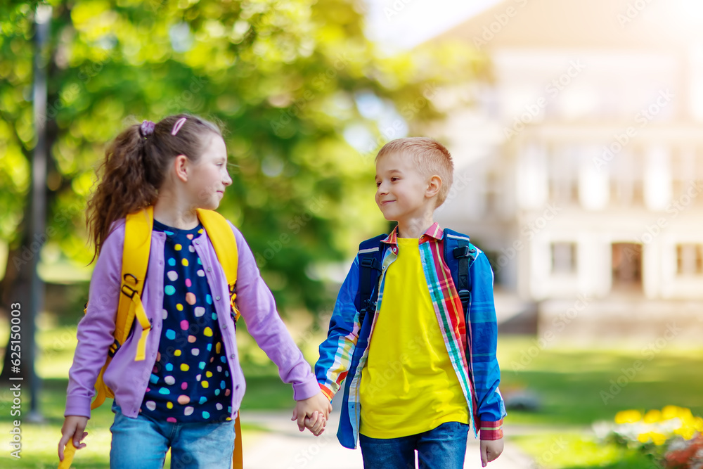 Girl and boy going from school by holding hands.