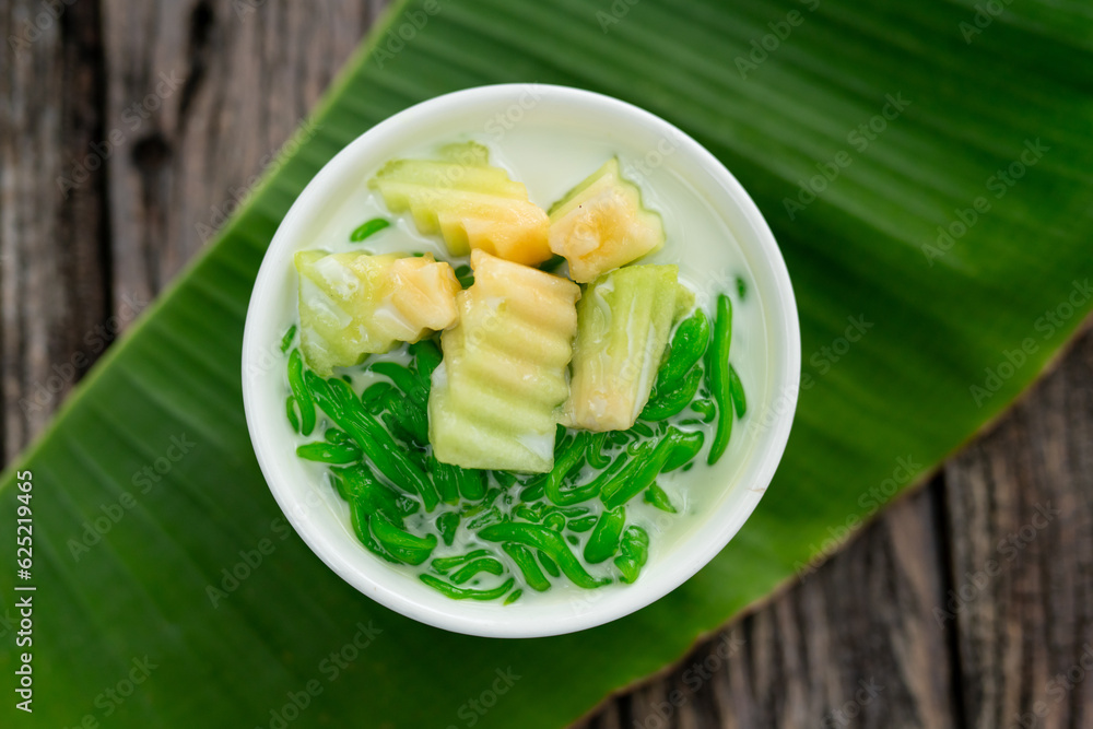 Appetizing Lod Chong placed on a green banana leaf on a wooden table.