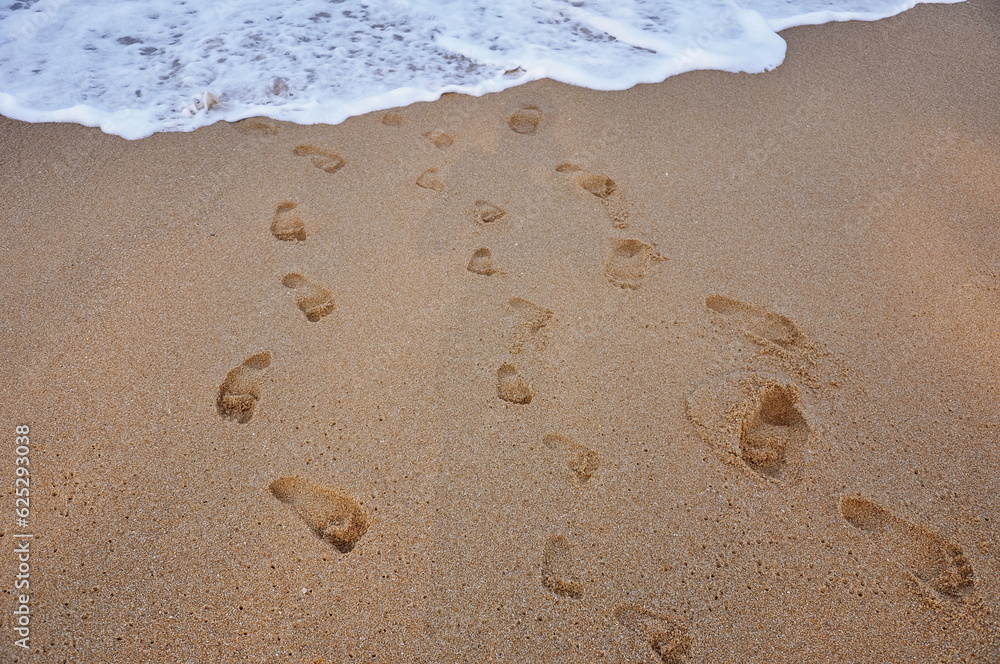 Child footprints on sand sea shore