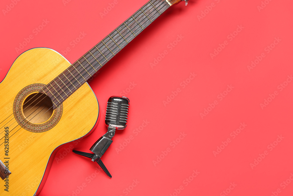 Acoustic guitar and microphone on color background