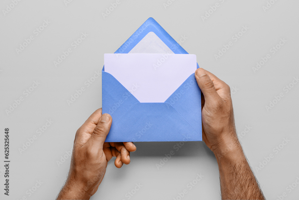 Male hands with envelope and blank card on white background, closeup