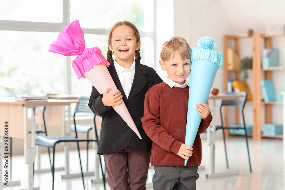 Happy classmates with colorful school cones in classroom