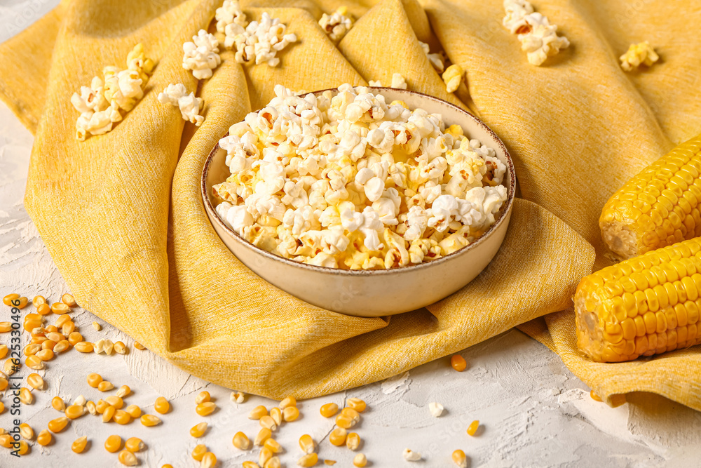 Bowl with tasty popcorn and seeds on grey background