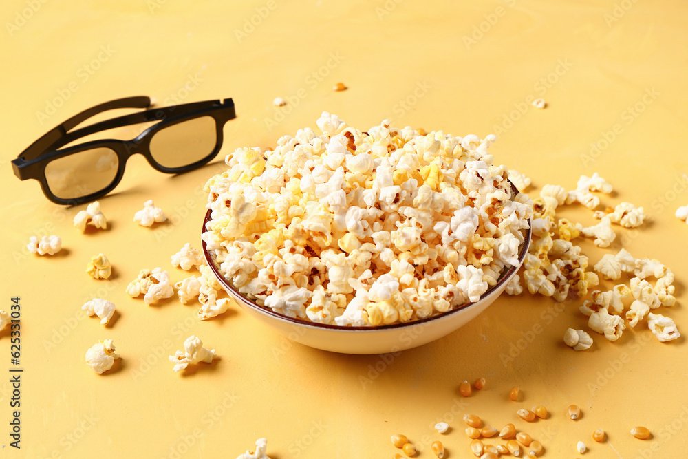 Bowl with tasty popcorn and 3D glasses on yellow background