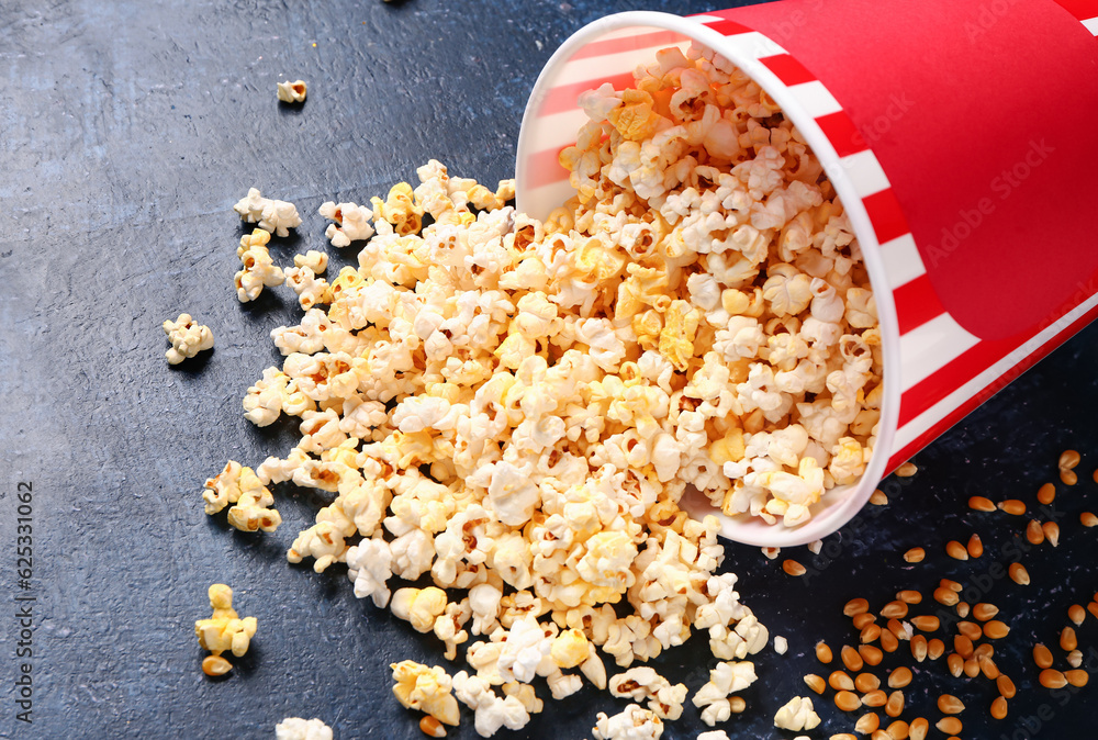 Bucket with tasty popcorn on blue background