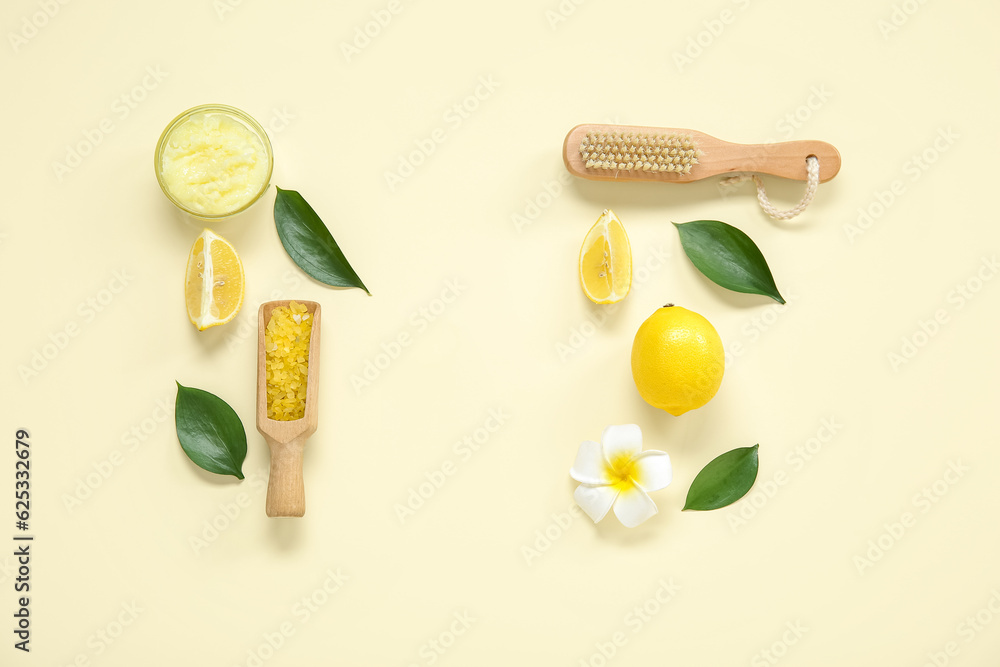 Bowl of lemon body scrub with massage brush and sea salt on pale yellow background