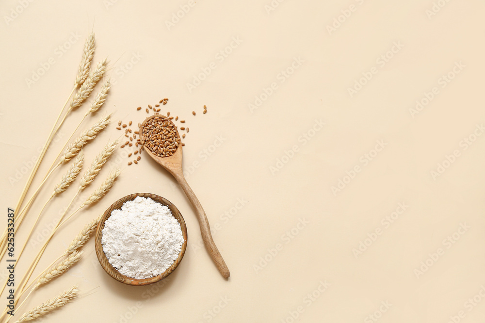 Wheat flour in bowl, spoon with grains and spikelets in beige background