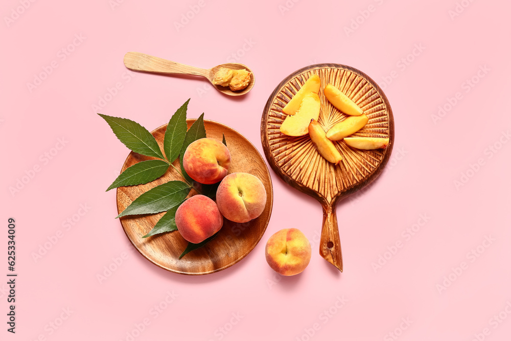 Plate of sweet peaches and wooden board with pieces on pink background