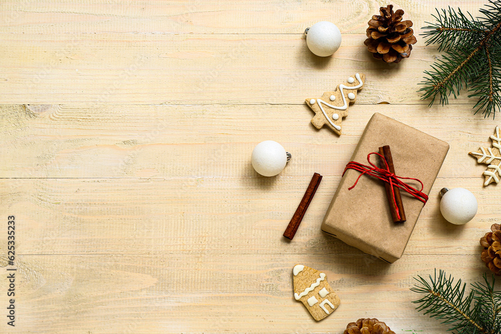 Christmas balls, gingerbread cookies and gift box on wooden background