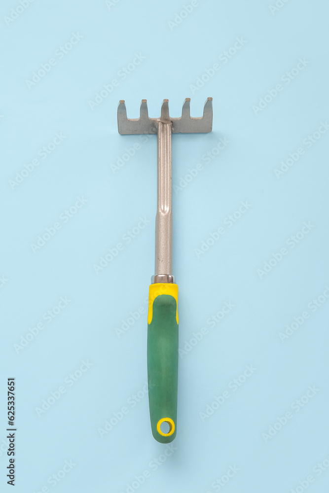 Gardening rake on blue background