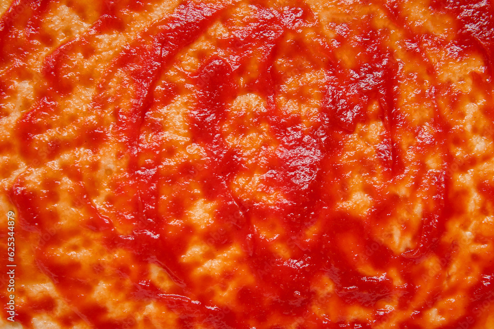 Pizza crust with tomato sauce as background, closeup